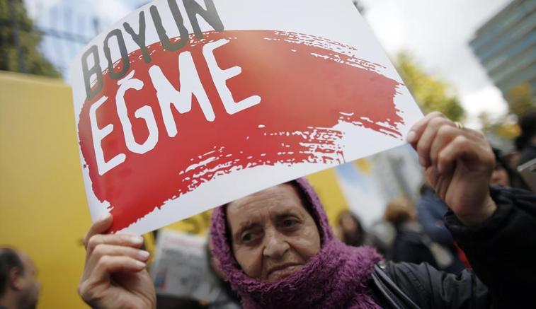 Donna col cartello «Non abbassare la testa» davanti alla redazione di Cumhuriyet , giornale nel mirino di Erdogan